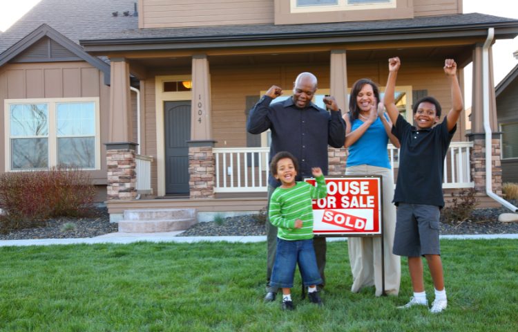 Family standing infront of the house they bought