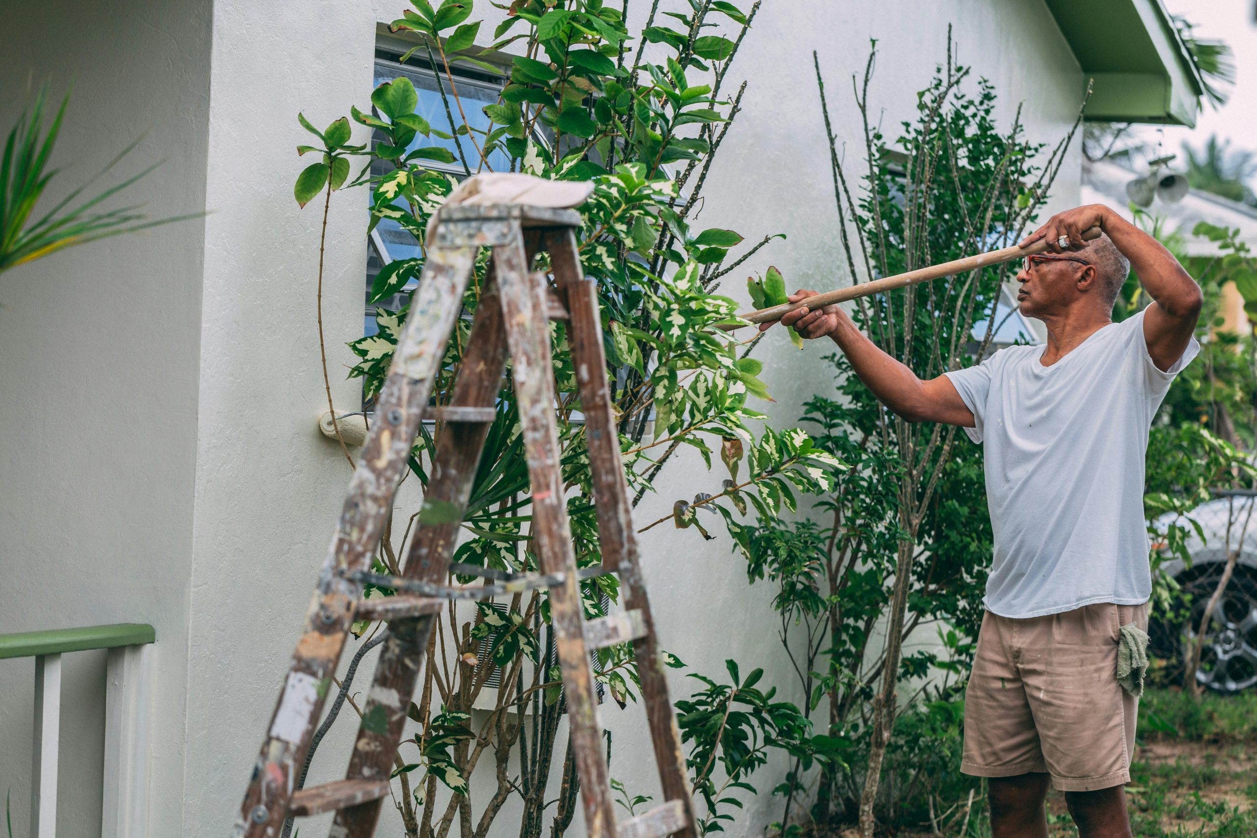A male fixing the exterior of his house